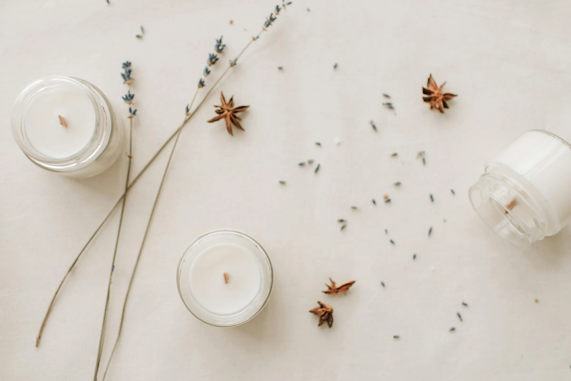 Spa still life with candles, star anise, and lavender on a soft linen surface